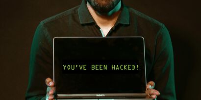 Man holding laptop computer with both hands